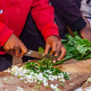 grünes Balttgemüse wird geschnitten für eine Mahlzeit im Wohnheim ALABRI